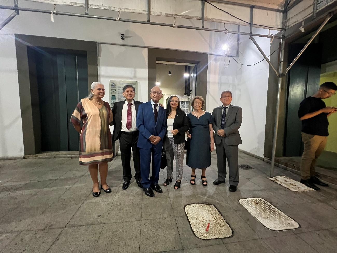 Membros da ACBJ-BA posam ao lado de Roberto Fudio Mizushima em área externa da Câmara Municipal após a sessão solene.
