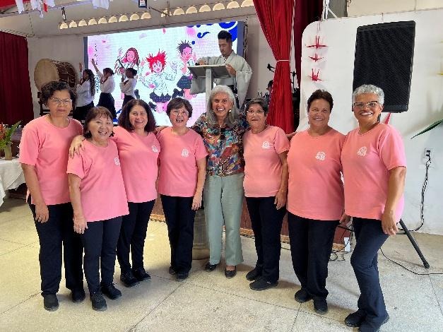 Integrantes do grupo de Kenkou Taisou posam para foto ao lado da vice-presidente da ACBJ-BA, todas sorrindo e usando camisetas rosa.