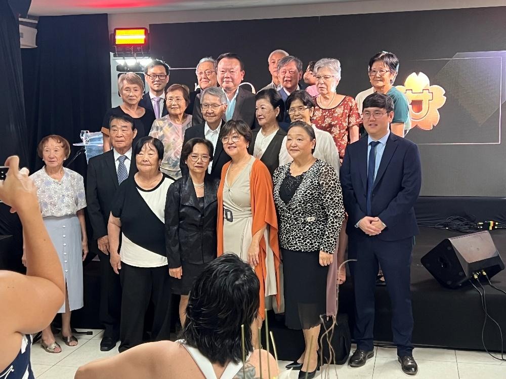 Grupo de fundadores e ex-presidentes da ANISA posa para foto coletiva em palco, durante a celebração dos 50 anos da Associação.