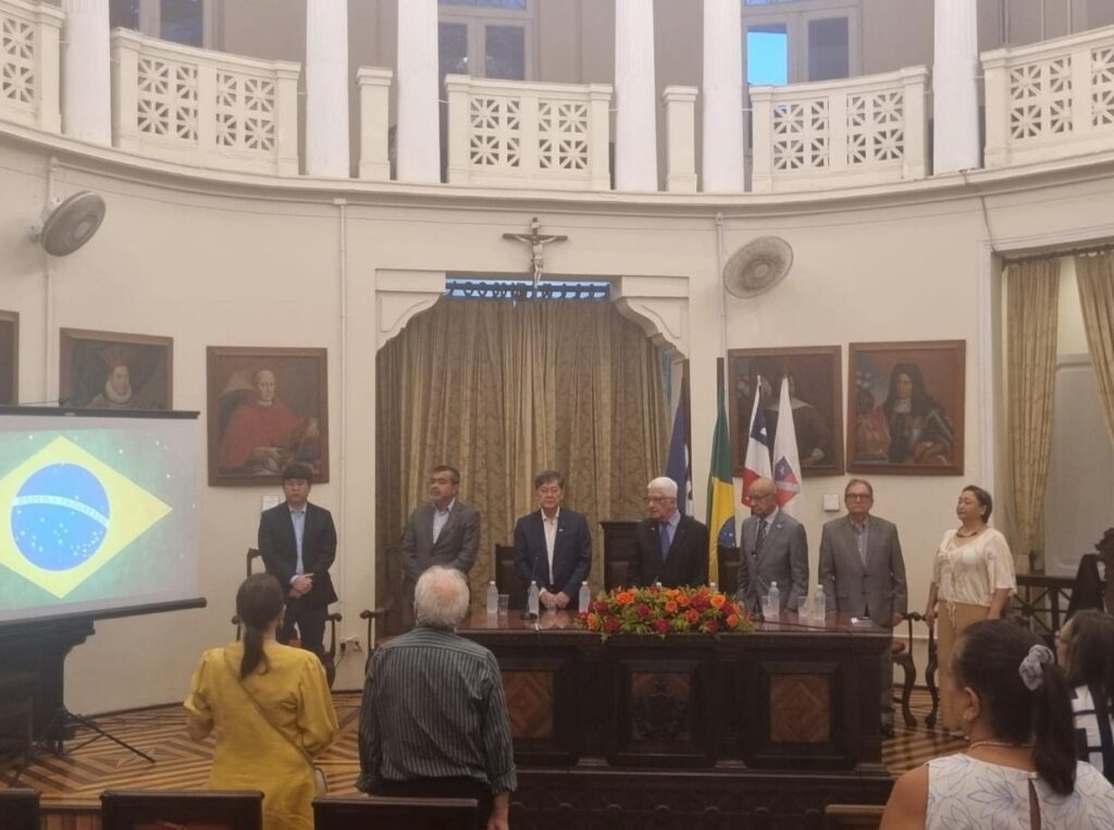Autoridades e representantes institucionais durante cerimônia de homenagem a Emilton Moreira Rosa no IGHB, com mesa solene e bandeiras ao fundo.